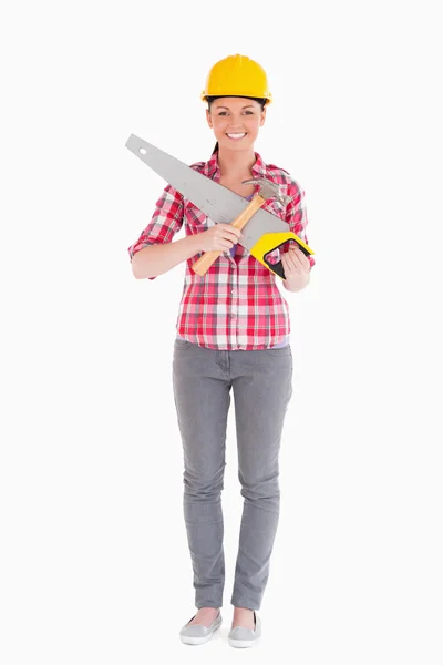 Beautiful woman holding a saw while standing — Stock Photo, Image