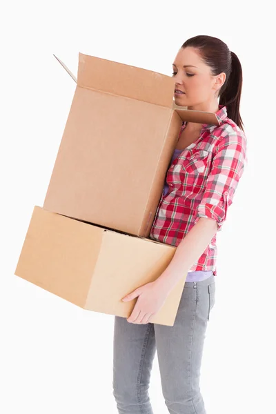 Beautiful woman looking inside a cardboard box while standing — Stock Photo, Image