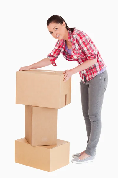 Iyi görünümlü bir kadın dururken karton kutular ile poz — Stok fotoğraf