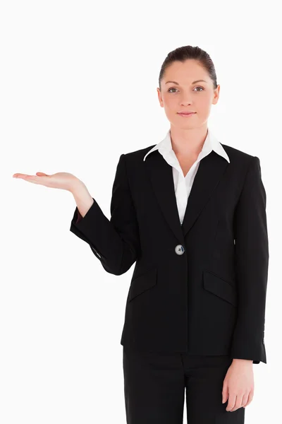 Attraktiv kvinna i kostym visar en kopia utrymme stående — Stockfoto
