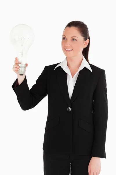 Krásná žena v obleku drží žárovku stoje — Stock fotografie