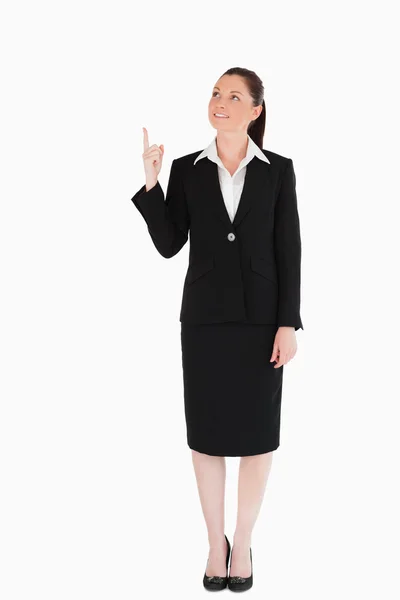Mulher atraente de terno apontando para um espaço de cópia — Fotografia de Stock