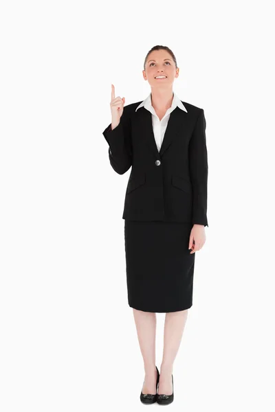Charmig kvinna i kostym som pekar på en kopia utrymme — Stockfoto