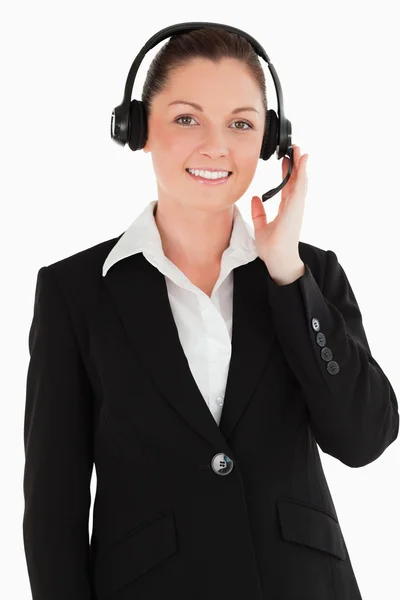 Portrait of a good looking woman in suit using headphones and po — Stock Photo, Image
