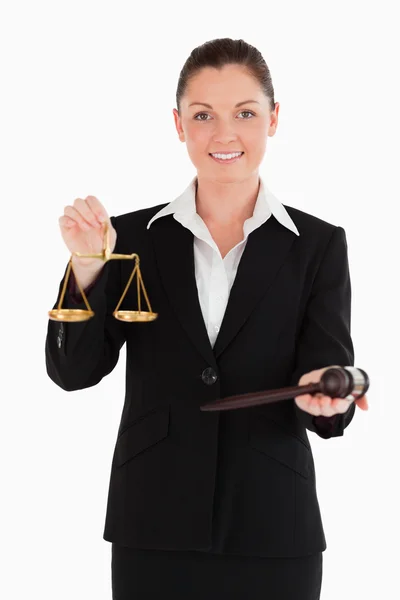 Gut aussehende Frau im Anzug mit einer Waage der Gerechtigkeit und einem Hammer — Stockfoto