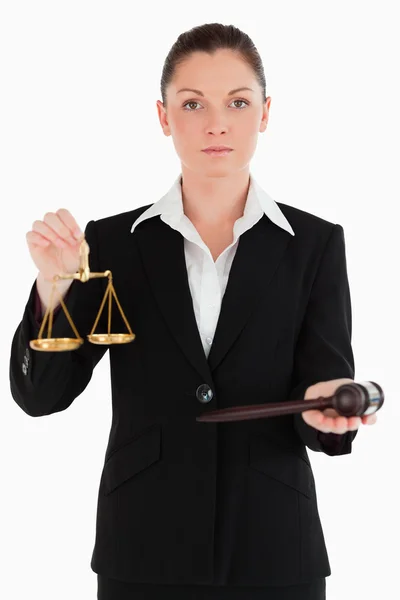 Pretty woman in suit holding scales of justice and a gavel — Stock Photo, Image
