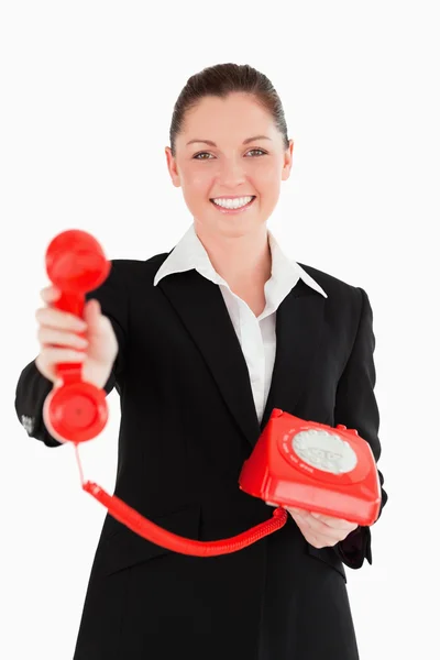 Iyi görünümlü kadın elbiseli kırmızı telefon tutarak — Stok fotoğraf