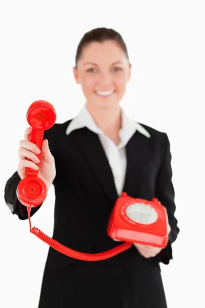 Όμορφη γυναίκα σε κοστούμι κρατώντας ένα κόκκινο τηλέφωνο — Φωτογραφία Αρχείου