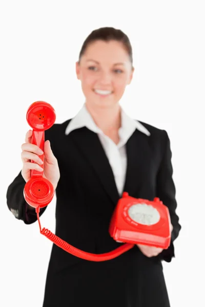Kırmızı telefon tutarak elbiseli çekici kadın — Stok fotoğraf