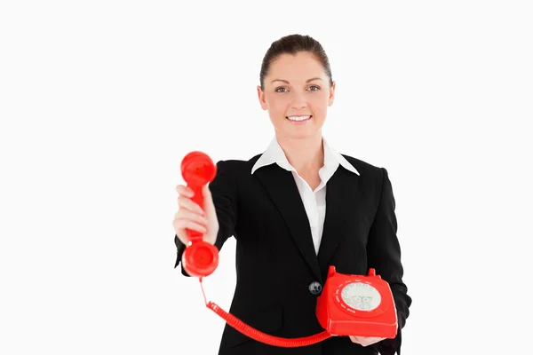 Charmig kvinna i kostym håller en röd telefon — Stockfoto
