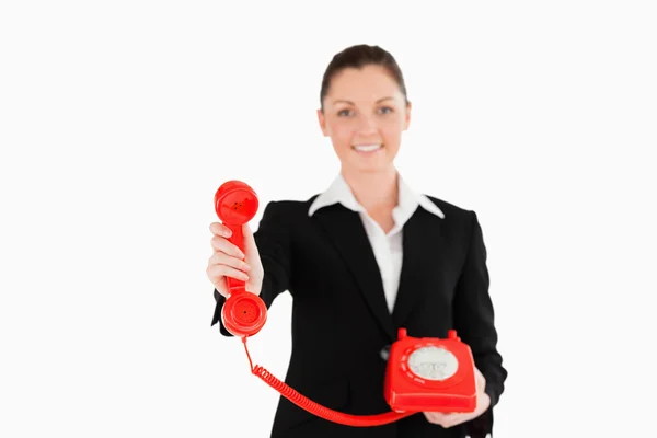 Mulher bonita de terno segurando um telefone vermelho — Fotografia de Stock