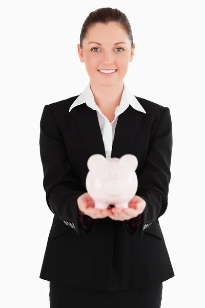 Aantrekkelijke vrouw in pak houden een roze piggy bank — Stockfoto