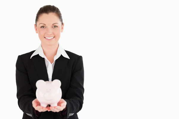 Charming woman in suit holding a pink piggy bank — Stock Photo, Image