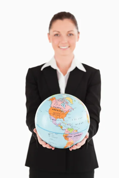 Knap vrouwelijke in pak een globe houden — Stockfoto