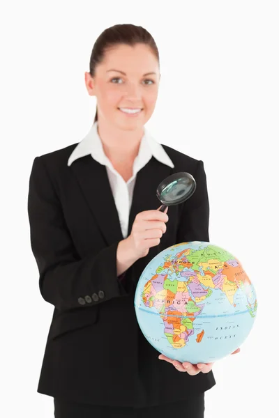 Attraktive Frau im Anzug mit Globus und Lupe — Stockfoto