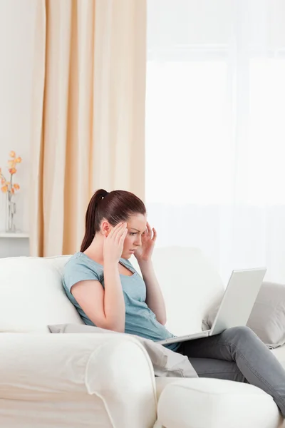 Beautiful upset woman gambling with her computer while sitting o — Stock Photo, Image