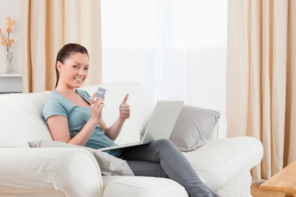 Mujer atractiva haciendo un pago en línea con su tarjeta de crédito w —  Fotos de Stock