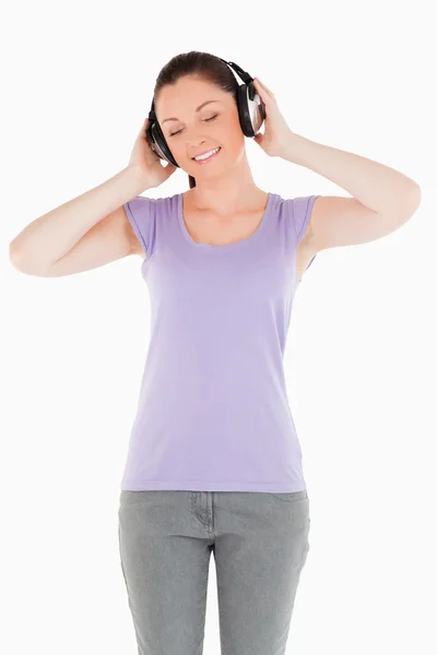 ゴージャスな女性が立っているヘッドフォンでポーズ — ストック写真