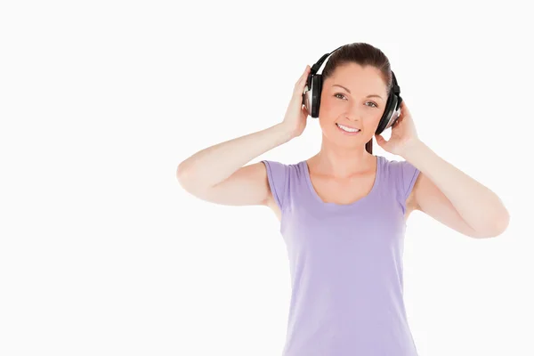 Charming woman posing with headphones while standing — Stock Photo, Image