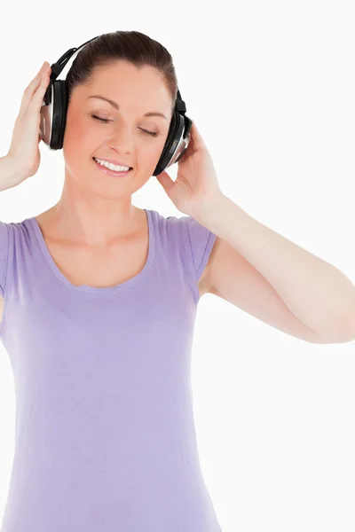 Ελκυστική γυναίκα που ποζάρει με ακουστικά, ενώ στέκεται — ストック写真