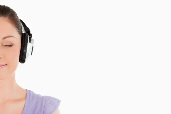 Porträt einer attraktiven Frau, die mit Kopfhörern posiert, während — Stockfoto