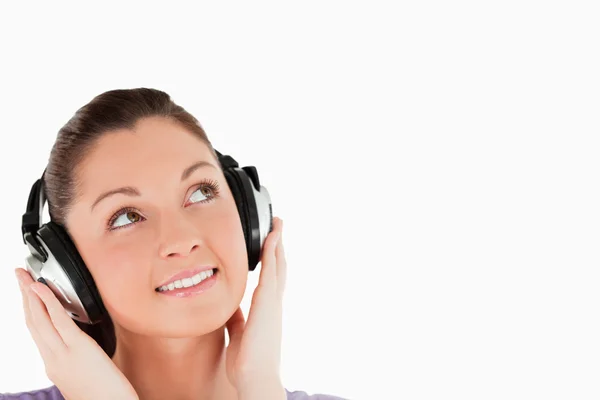 Portrait of a lovely woman posing with headphones while standing — Stock Photo, Image