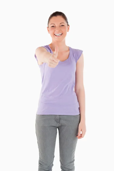 Bra kvinna poserar med sin tumme upp stående — Stockfoto