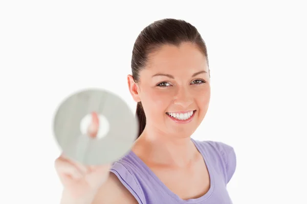 Beautiful woman holding a CD while standing — Stock Photo, Image