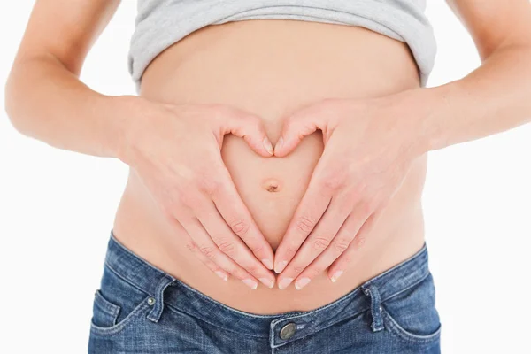 Close-up of a young pregnant female posing while forming a heart Stock Image