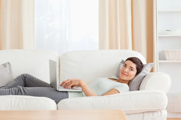 Mulher relaxante com um laptop Imagem De Stock