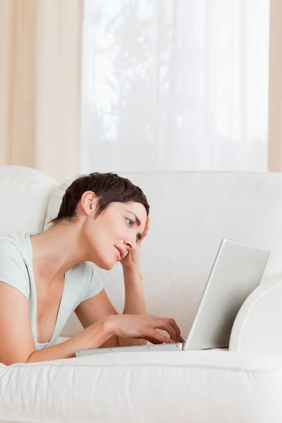 Tired brunette using a laptop Stock Image