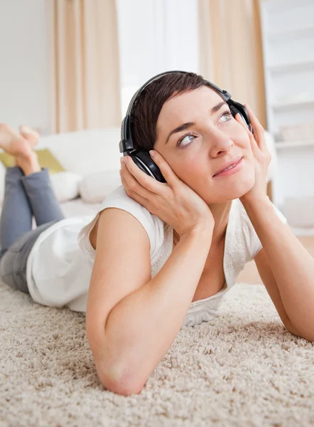 Portrait of a dreaming woman listening to music — Stock Photo, Image