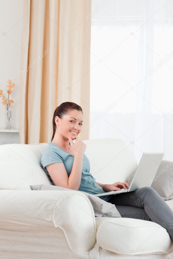 Gorgeous woman relaxing with her laptop while sitting on a sofa Stock ...