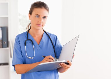 Doctor holding an open folder and having a stethoscope around he clipart