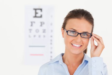 Close up of abrunette eye specialist wearing glasses looking int clipart