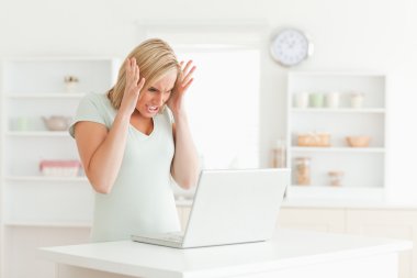 Upset woman looking at her laptop clipart