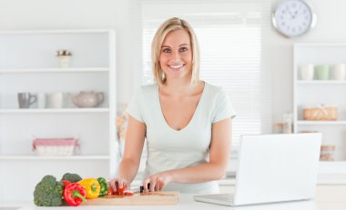 Close up of a young woman looking into camera while cutting pepp clipart