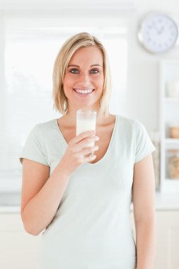 Woman holding glass filled with milk clipart