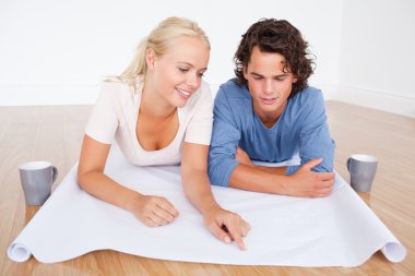 Woman showing a point on a plan to her fiance clipart