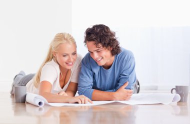 Smiling couple getting ready to move in a new house clipart