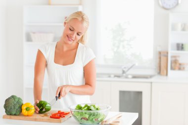 Beautiful woman slicing pepper clipart