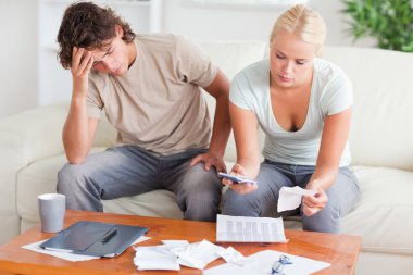 Stressed couple calculating their expenses clipart