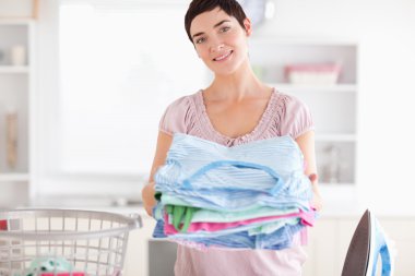 Brunette Woman with a pile of clothes clipart