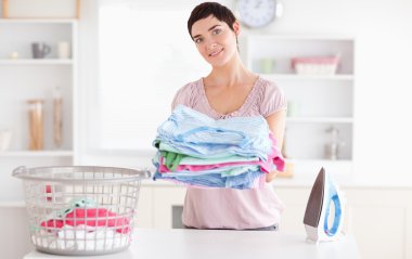 Beautiful Woman with a pile of clothes clipart