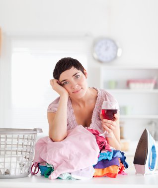 Brunette Woman with wine and a pile of clothes clipart