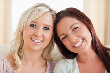 Happy women lounging on a sofa clipart