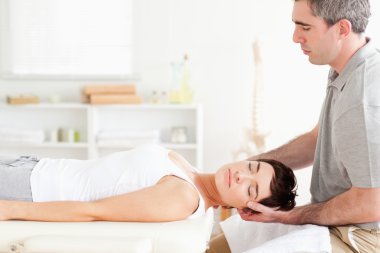 Chiropractor stretching a charming woman clipart