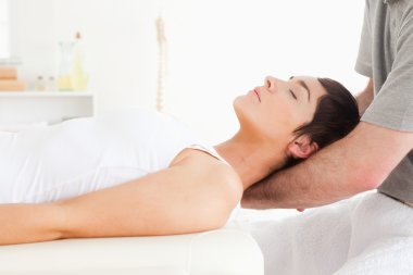 Woman relaxing during a massage clipart