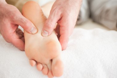 Man massaging a woman's foot clipart