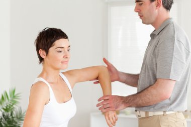 Chiropractor working on a woman's arm clipart